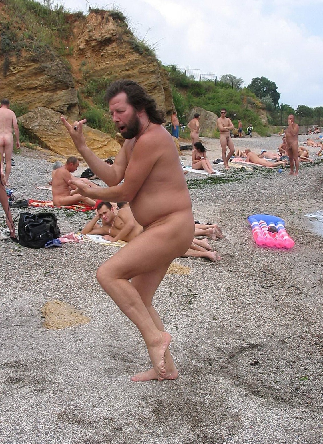 Energetic beachside dancing by a spirited nudist man, reveling in the beauty of movement