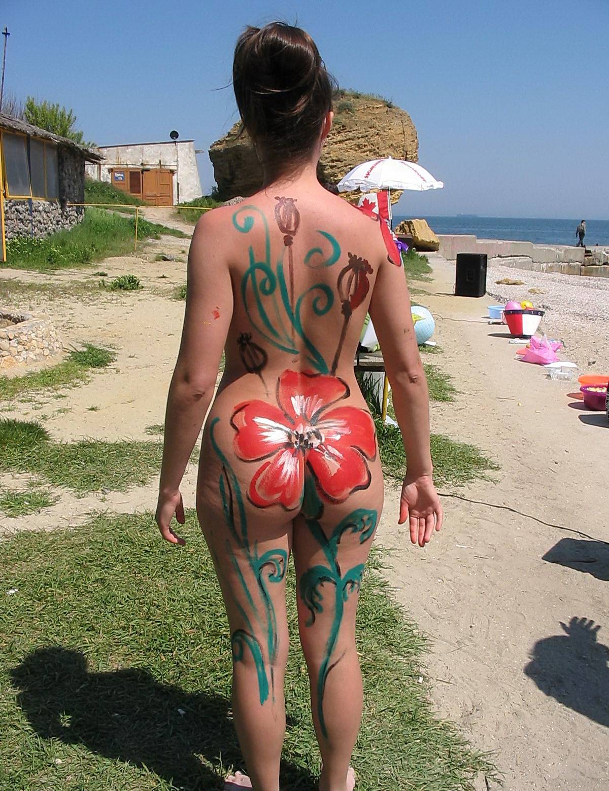 Captivating image of a woman embracing her natural beauty with body painting, amidst the beach and sea